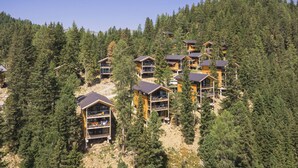 Un conjunto de cabañas de madera de varios pisos, rodeadas de un denso bosque.
