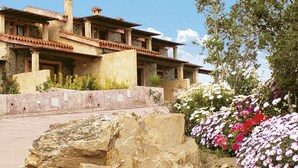 Un edificio grande y rústico con fachada de piedra y varias chimeneas.