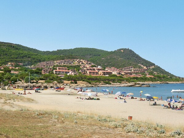 A coastal resort with multiple buildings, a sandy beach, and a clear view of the sea. - Turri Motta (PCR150) by Interhome (Porto Corallo)