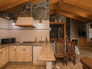 Een koelkast, een oven, een vaatwasser, kookgerei, borden en bestek