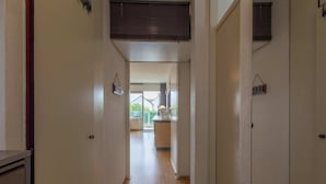 A narrow hallway with a kitchen area in the background. - Apartment in Callantsoog near the dunes (Callantsoog)