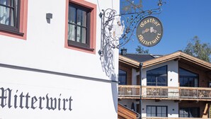 Un bâtiment sur lequel on peut lire l’inscription « Gasthof Gitterwart » et qui possède un balcon avec des balustrades en bois.