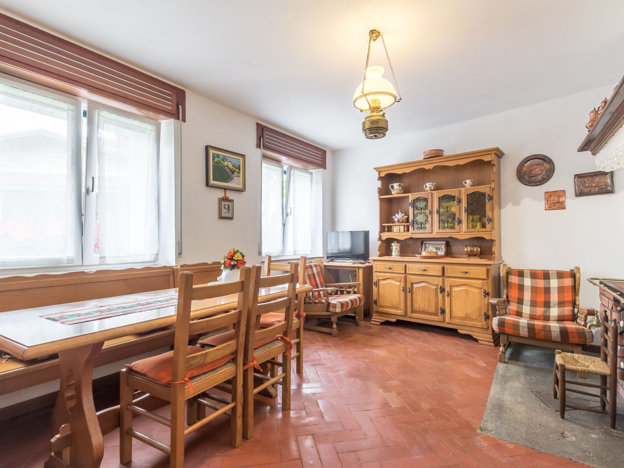Un coin repas avec des meubles en bois, un téléviseur et un meuble décoratif.