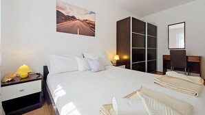 A hotel room with a bed, a desk, a chair, a wardrobe, a lamp, and a picture on the wall. - Vacation home Ana by Interhome (Brač/Supetar)