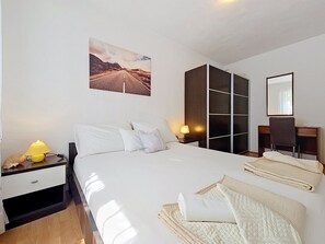 A hotel room with a bed, a desk, a chair, a wardrobe, a lamp, and a picture on the wall. - Vacation home Ana by Interhome (Brač/Supetar)