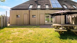 Un bâtiment en bois doté d’un toit en pente, d’une porte et d’une fenêtre.