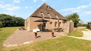 A wooden building with a sloped roof, a front door, and a small window.