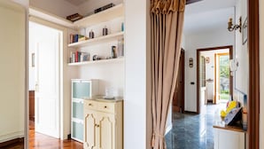 A room with a wooden floor, a white cabinet with drawers, a small white desk, and a bookshelf with books and decorative items. - La Casetta by Interhome (Diano Marina)