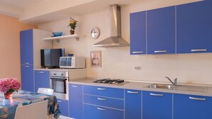Une cuisine moderne avec des meubles bleus, un four à micro-ondes, une cuisinière et un évier.