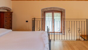A bedroom with a wooden ceiling, a bed, a dresser, and a window with a balcony. - Vince (DOX200) by Interhome (Dorio)
