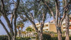 A hotel with a garden area featuring trees and a pathway. - Apartment Sara by Interhome (Santo Stefano al Mare)