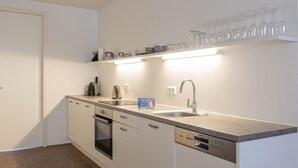 A modern kitchen with a dishwasher, oven, and a coffee machine.
