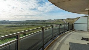 A balcony with a view of a bridge and distant hills. - Wijde Blick 205 apartment with balcony (Callantsoog)