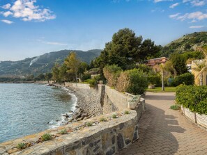 A coastal walkway with a stone wall, greenery, and a view of the sea and hills. - Apartment Botti by Interhome (Ventimiglia)