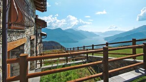 A stone building with a wooden balcony overlooking a lake and mountains. - Le Baite di Bodone by Interhome (Gravedona)