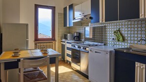 Une cuisine compacte avec un coin repas, une vue par la fenêtre et un pare-feu en carreaux.