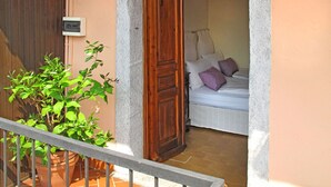 Una habitación con una cama, una planta en maceta y una puerta de madera.