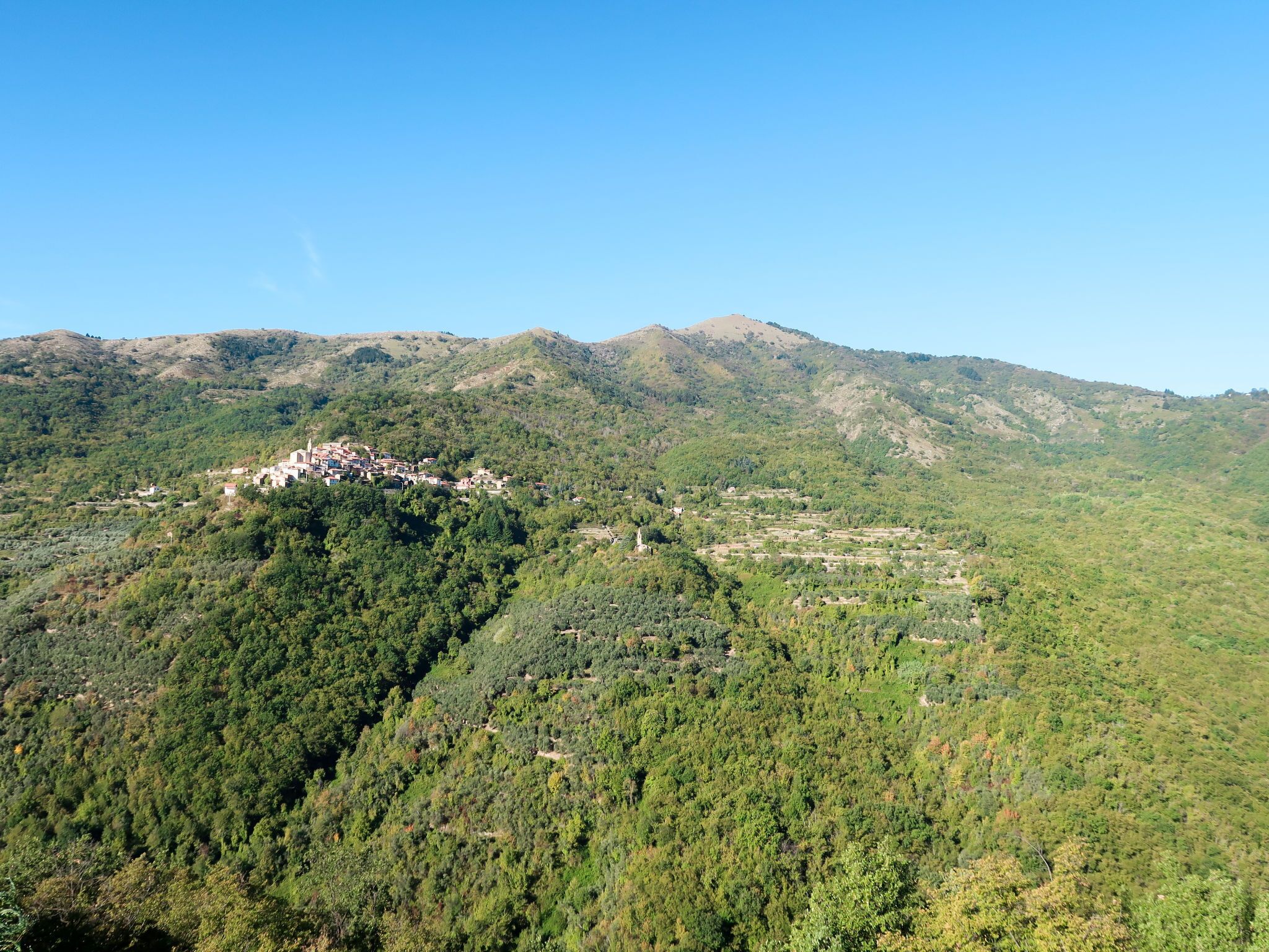 A mountainous landscape with a village nestled among the hills.