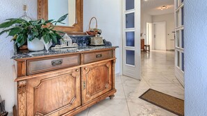 A wooden cabinet with drawers and a mirror above it, a potted plant, and a decorative item on the countertop. - Jadranka by Interhome (Novigrad (Istra))