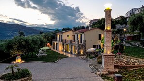 A villa with a paved driveway, stone pillars, and a well-maintained garden. - Freedom (IMP520) by Interhome (Imperia)