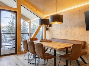 Ein Holzinterieur mit einem Esstisch, Stühlen und einer Bank.