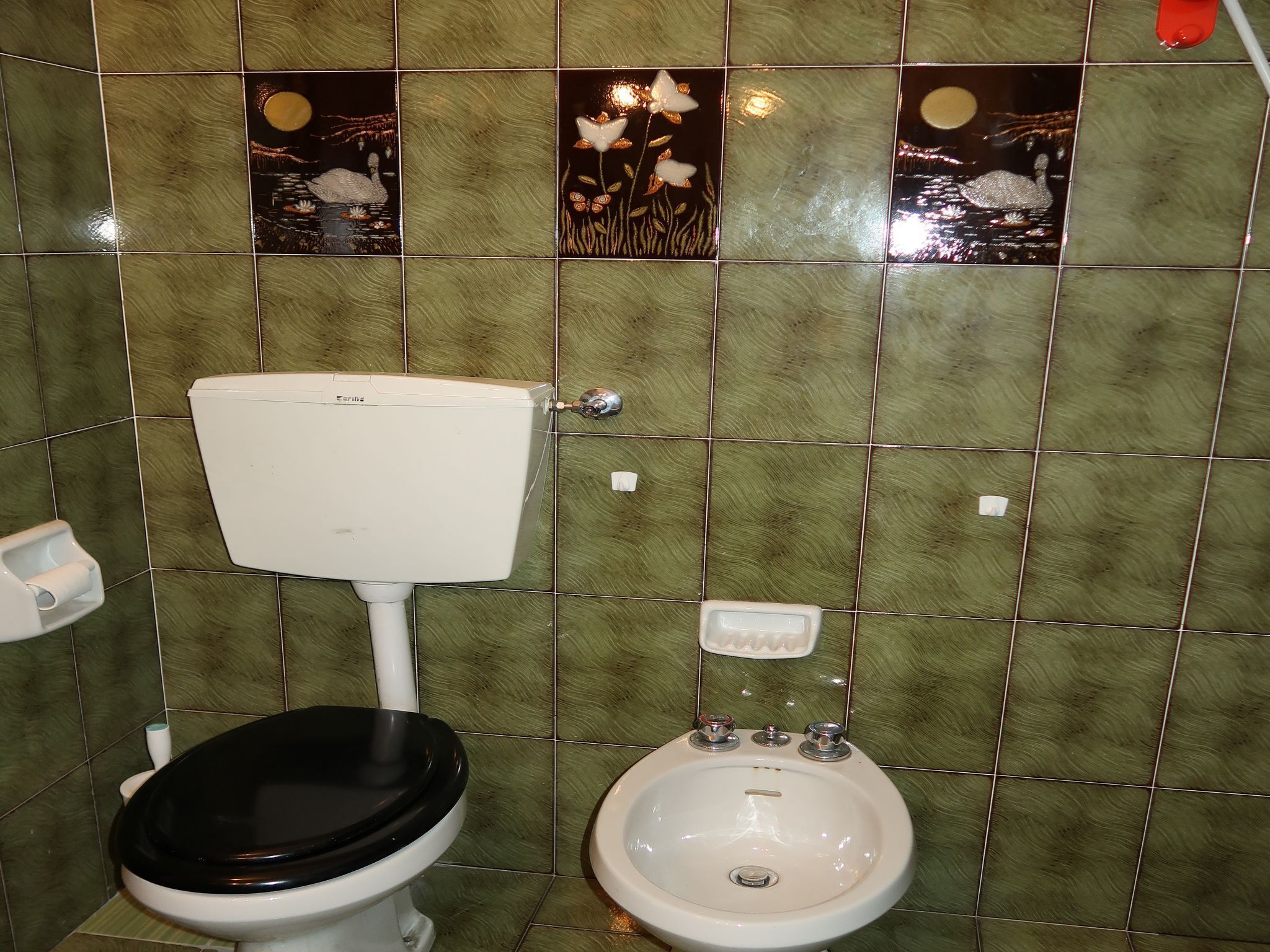 A bathroom with a toilet, bidet, and sink.