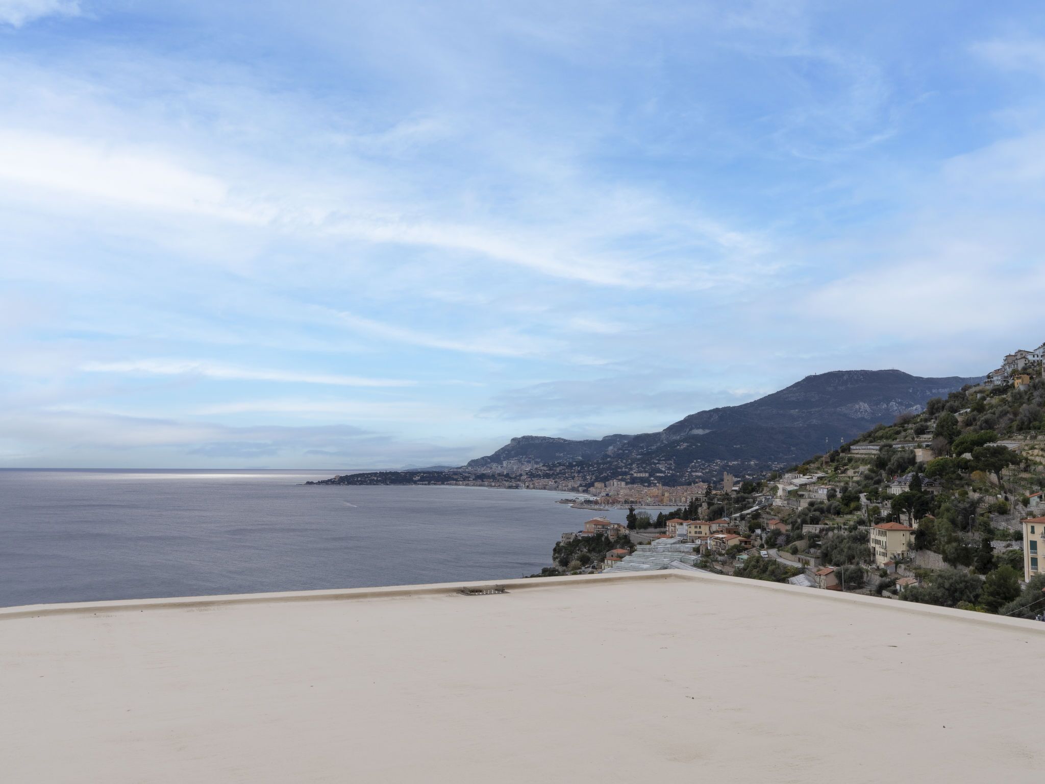 A coastal town with buildings on a hillside overlooking the sea.