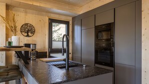 Cocina moderna con encimera de granito, electrodomésticos de acero inoxidable y armarios de madera.