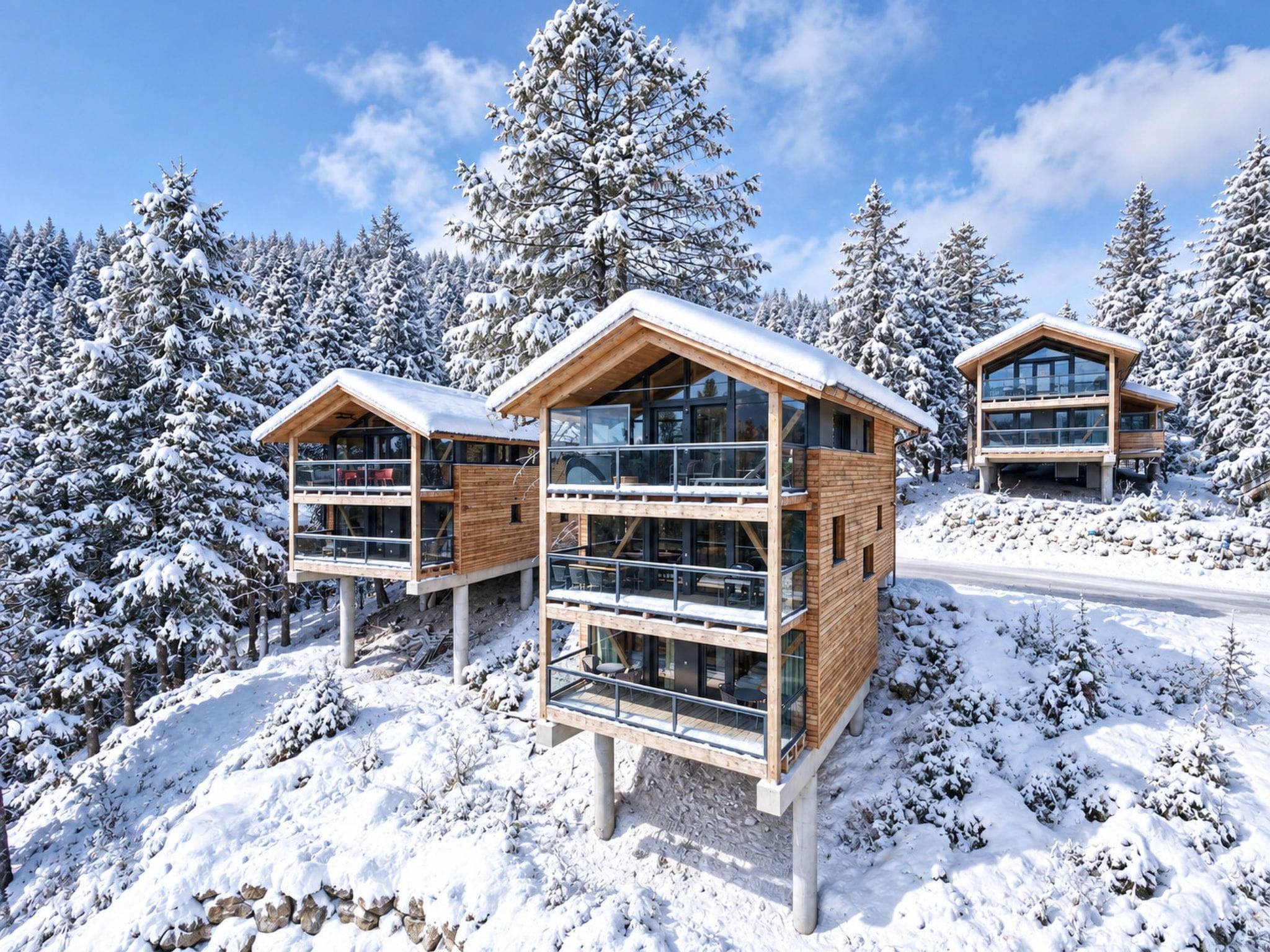A modern chalet with a wooden exterior, multiple balconies, and large windows, surrounded by snow-covered trees.