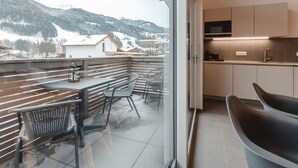 A modern kitchen with a view of snowy mountains.