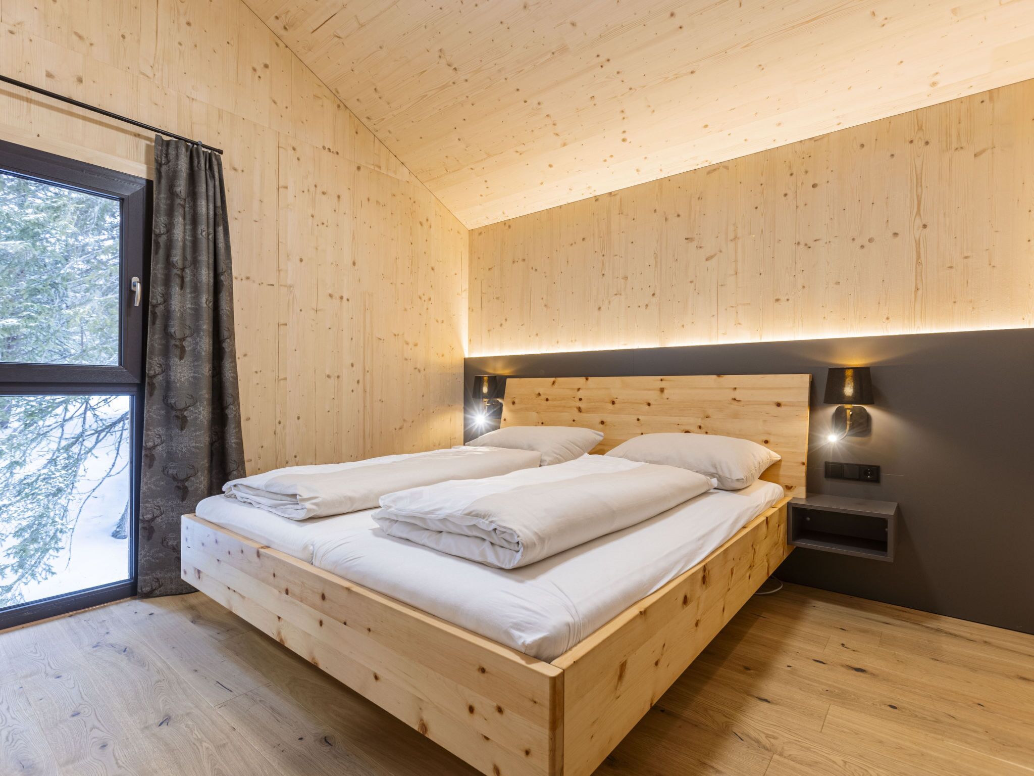 Une chambre à coucher en bois, avec un lit, des rideaux et une table de chevet.