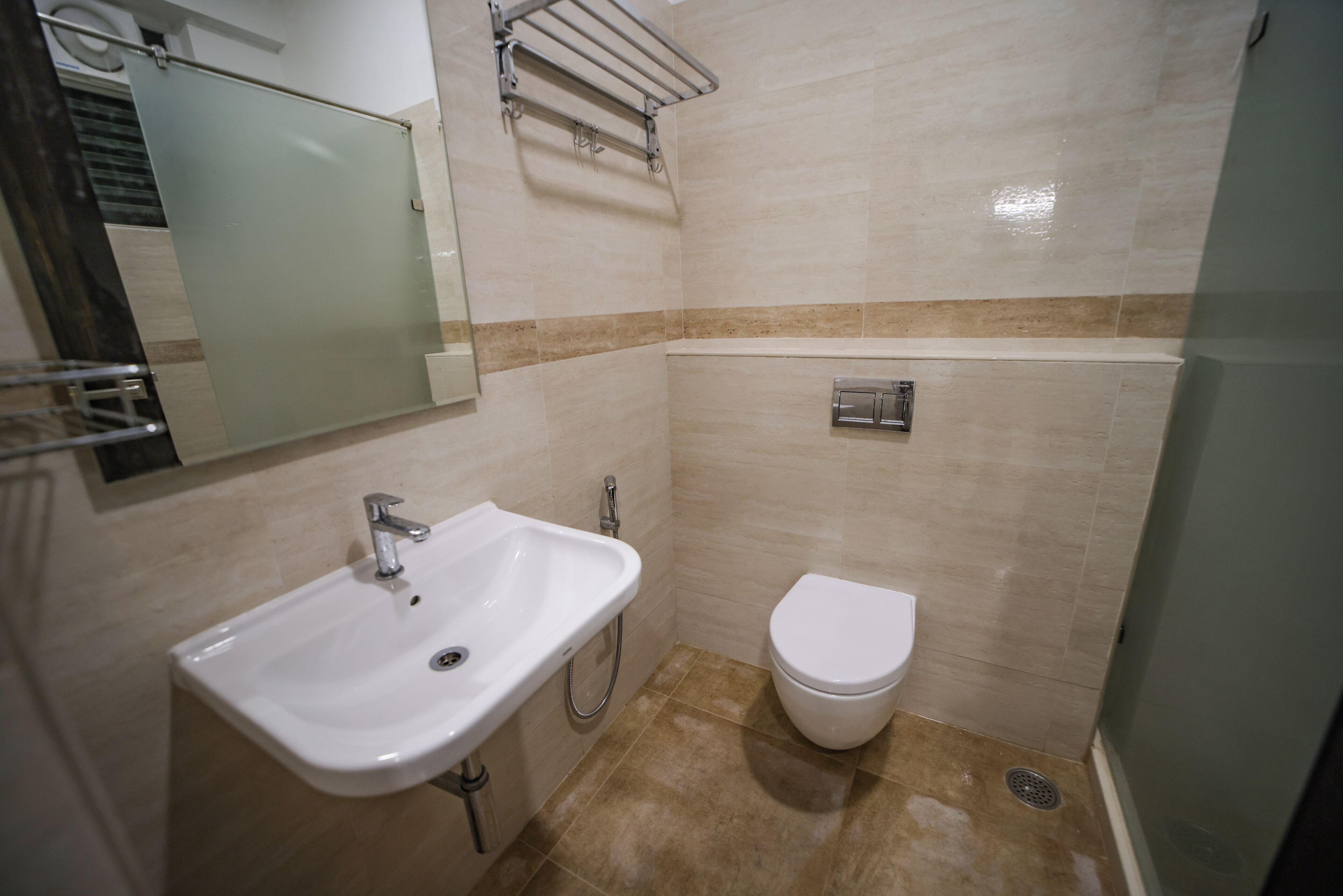 A bathroom with a sink, toilet, and a glass shower enclosure.