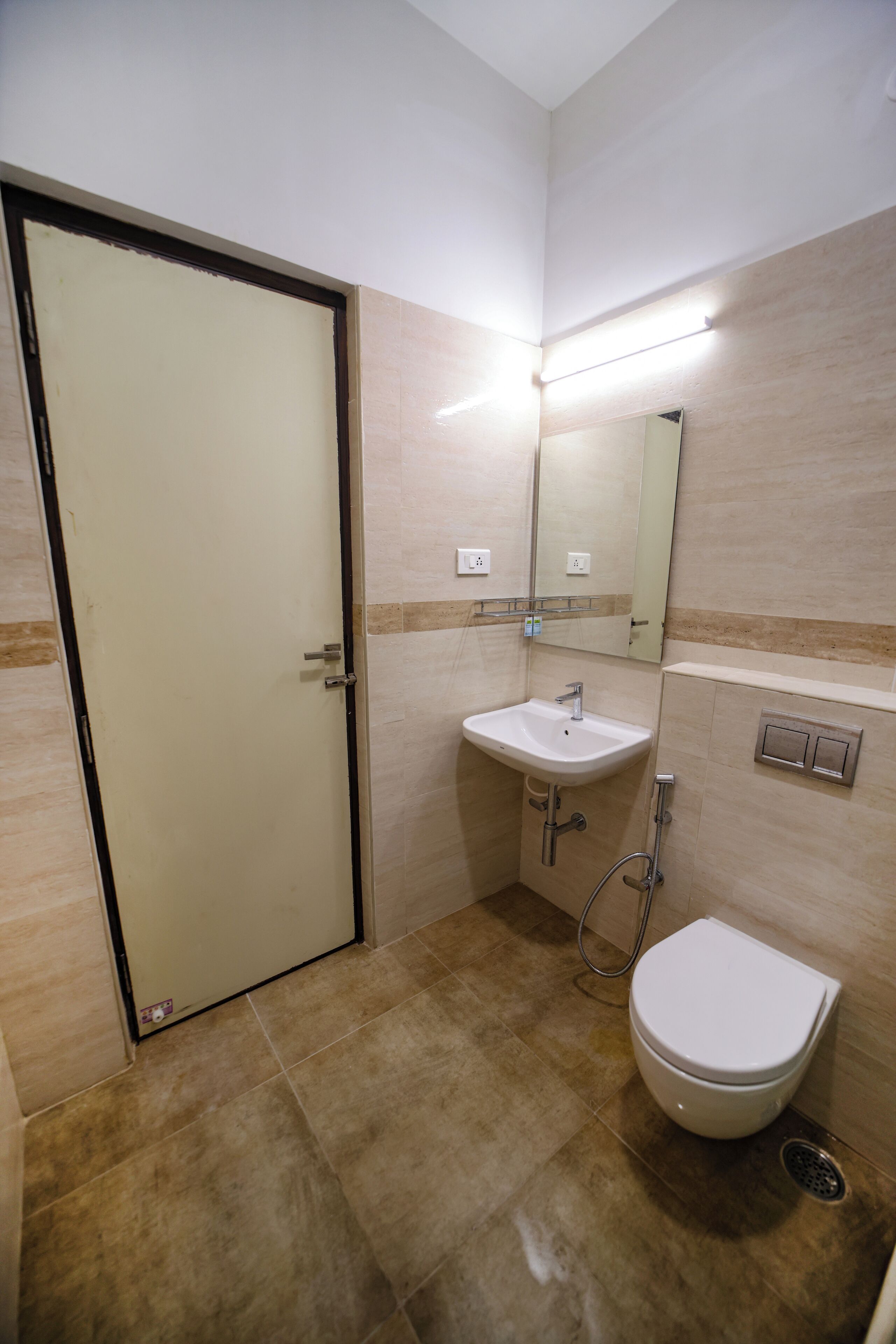 A small bathroom with a toilet, sink, and mirror.