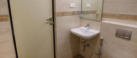 A small bathroom with a toilet, sink, and mirror.