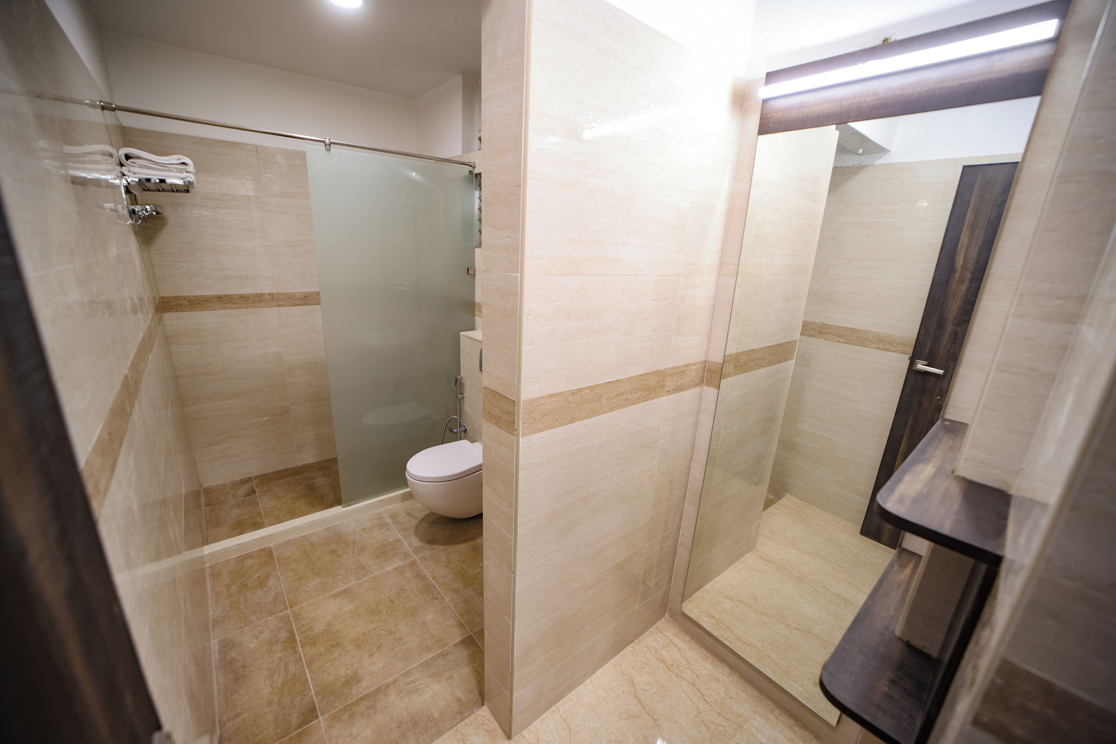 Une salle de bain moderne avec une douche à parois de verre, des toilettes et un meuble-lavabo avec un miroir.
