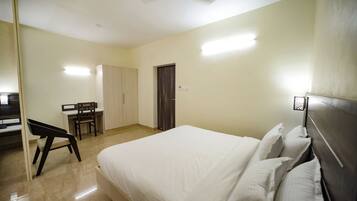 Un dormitorio con cama, escritorio y silla.