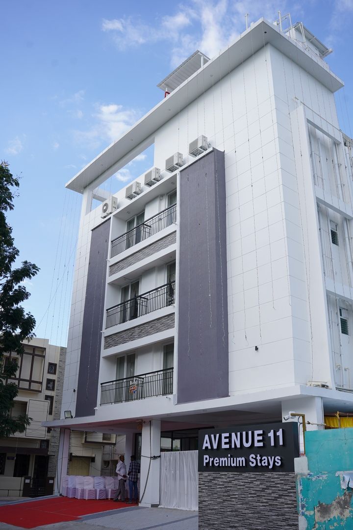 Un edificio de varios pisos con un letrero que dice 'AVENUE 11 Premium Stays'.
