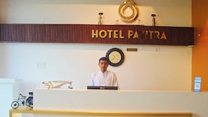 A hotel reception desk with a clock, a sign reading "HOTEL PAYTRA", and a reception area. - Hotel Pavitra (Purnia)