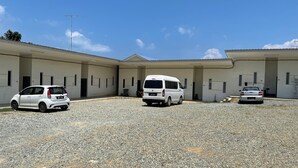 Un edificio con tres furgonetas blancas estacionadas frente a él.