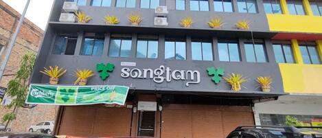 Un edificio con un letrero que dice 'Restoran Songtam' y un cartel anunciando descuentos.