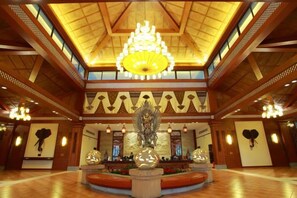 A spacious lobby with a grand chandelier, a central fountain, and a high ceiling with wooden beams. - Imperial Palace Hot Spring & Resort (Zijin)