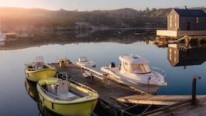 A marina with boats docked, a wooden dock, and a building with a sloped roof. - Vacation home Brosme by Interhome (Langevåg)