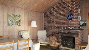 Um quarto aconchegante com lareira de tijolos, móveis de madeira e um quadro na parede.
