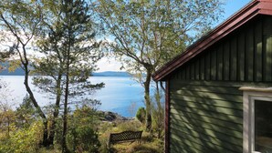 Uma cabana com vista para um lago e montanhas.