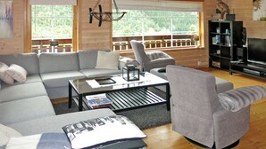 Ein gemütliches Wohnzimmer mit einer Eckcouch, einem Couchtisch und einem Fernseher.