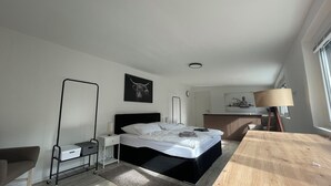 A modern bedroom with a bed, bedside table, lamp, and artwork. - Oase im Grünenhinterhof, EG, Ruhe, Terrasse, Carport, Free Paytv, Kaffee&tee, (Duisburg)