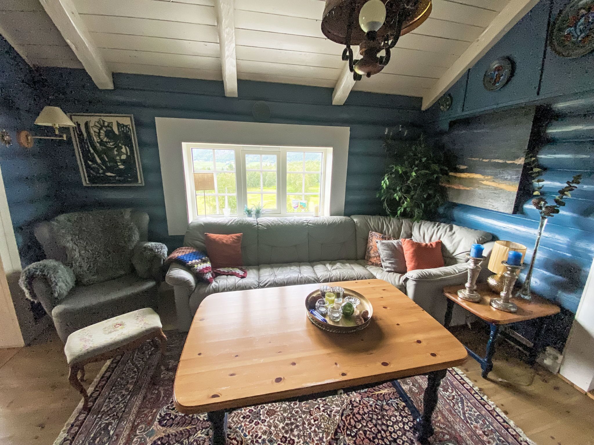 Una sala de estar acogedora con una mesa de centro de madera, un sofá gris y una alfombra estampada.