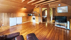 A cozy wooden cabin with a kitchen, living area, and a TV. - Naustet by Interhome (Åheim)