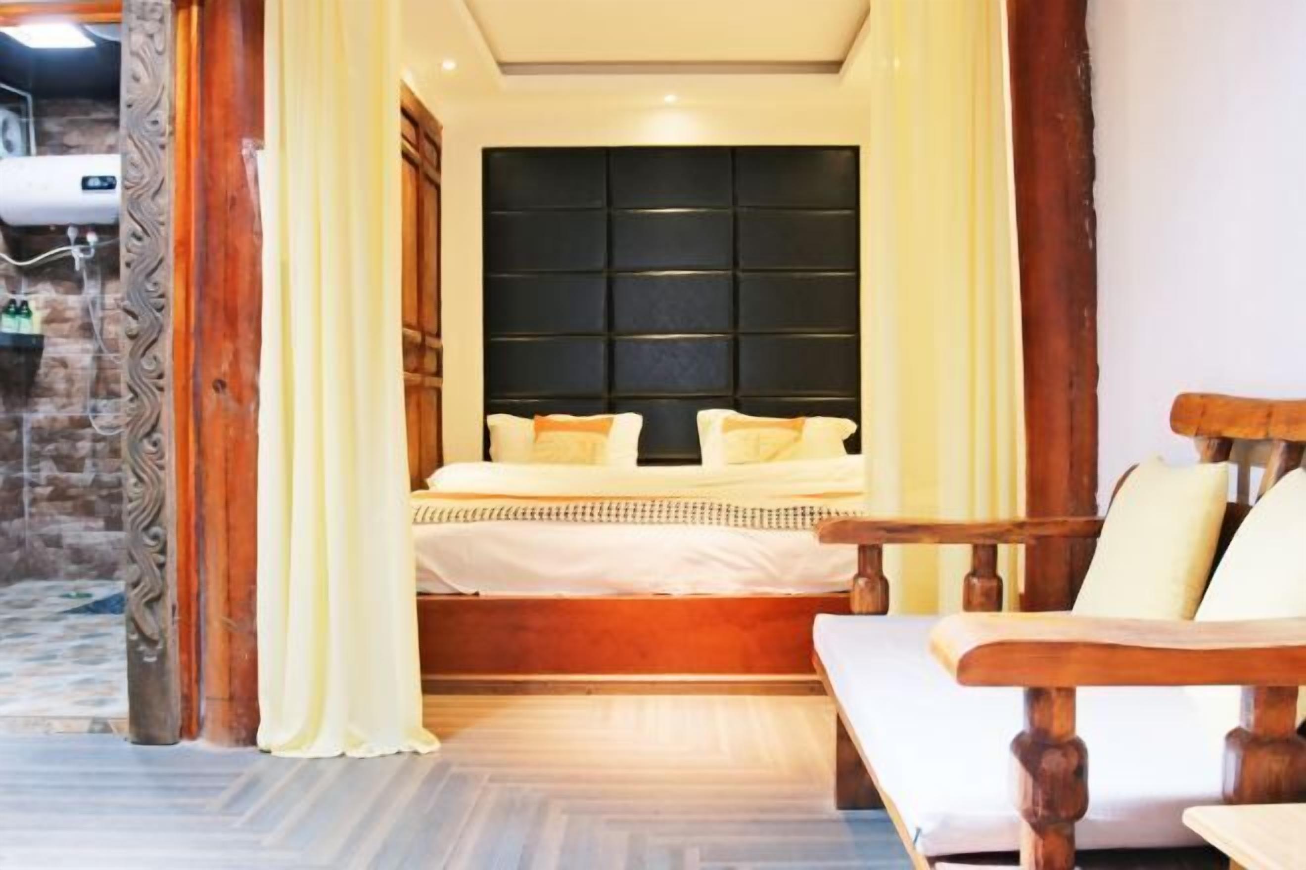 A bedroom with a large bed, wooden headboard, and a wooden bench.