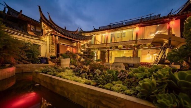 A traditional building with a courtyard, a pond, and potted plants. - Lijiang Yuanshu Inn (Shuhe Ancient Town Branch) (Lijiang)